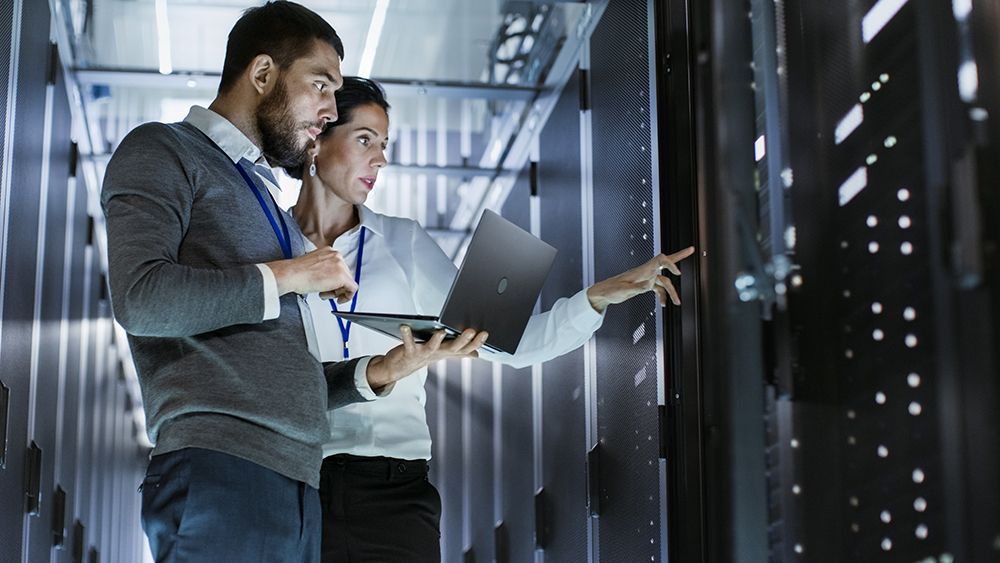 Picture of two persons working in a data center